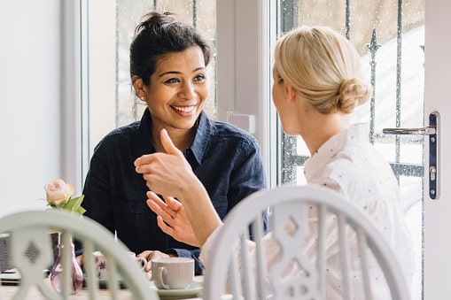 two women engaging in conversation and sharing breakfast together